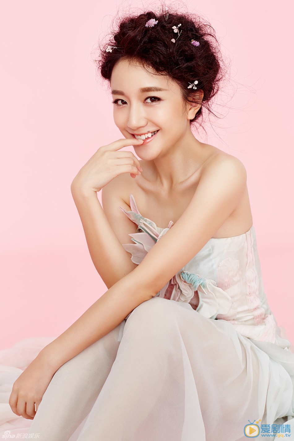 李倩小清新写真 写真中李倩时尚盘发上点缀粉色碎花，身着丝质粉蓝花裙优雅而灵动，香肩抢镜小露性感。李倩百变风格犹如粉色精灵，尽显甜美柔情。