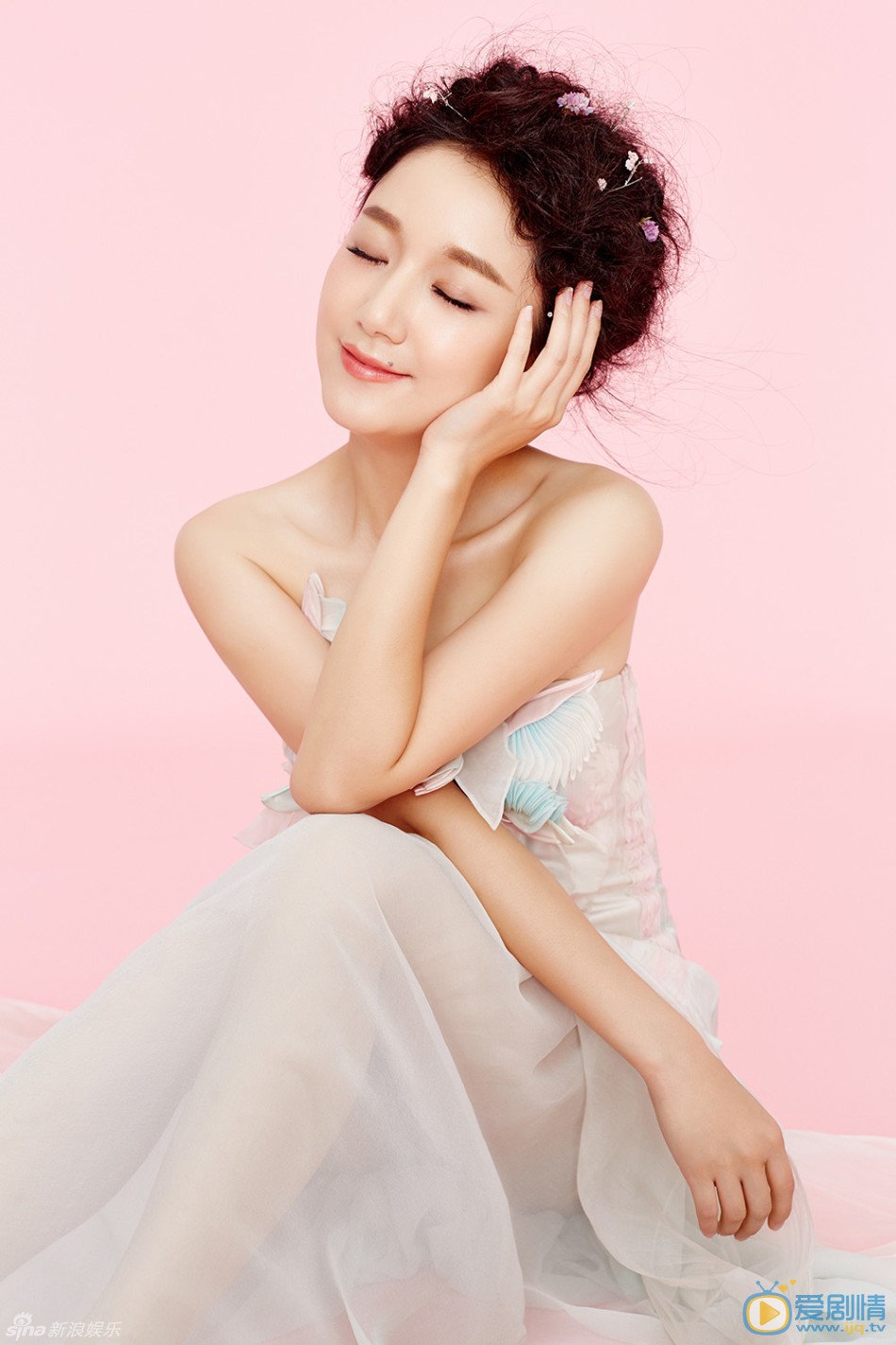 李倩小清新写真 写真中李倩时尚盘发上点缀粉色碎花，身着丝质粉蓝花裙优雅而灵动，香肩抢镜小露性感。李倩百变风格犹如粉色精灵，尽显甜美柔情。